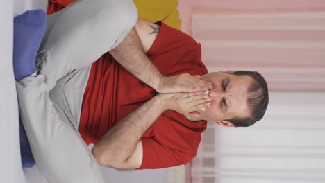 Vertical-video-of-Man-covering-his-mouth-and-nose-while-coughing.